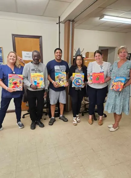St. Brigid's volunteers holding donated children's books.