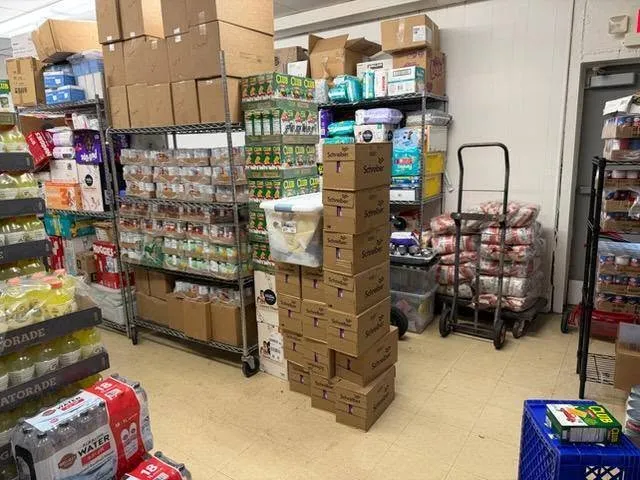 Pantry shelves and crates stocked with groceries and fresh produce.