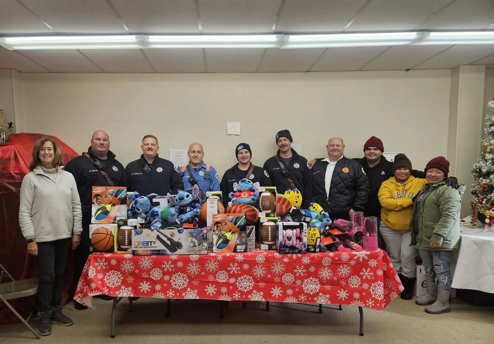 Volunteers with donated toys and books for children.