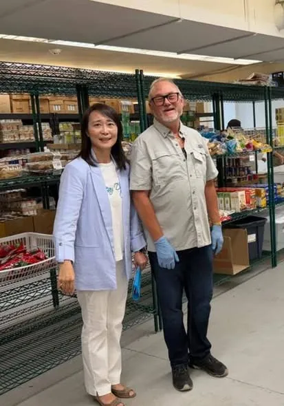 A volunteer welcoming visitors at the pantry.